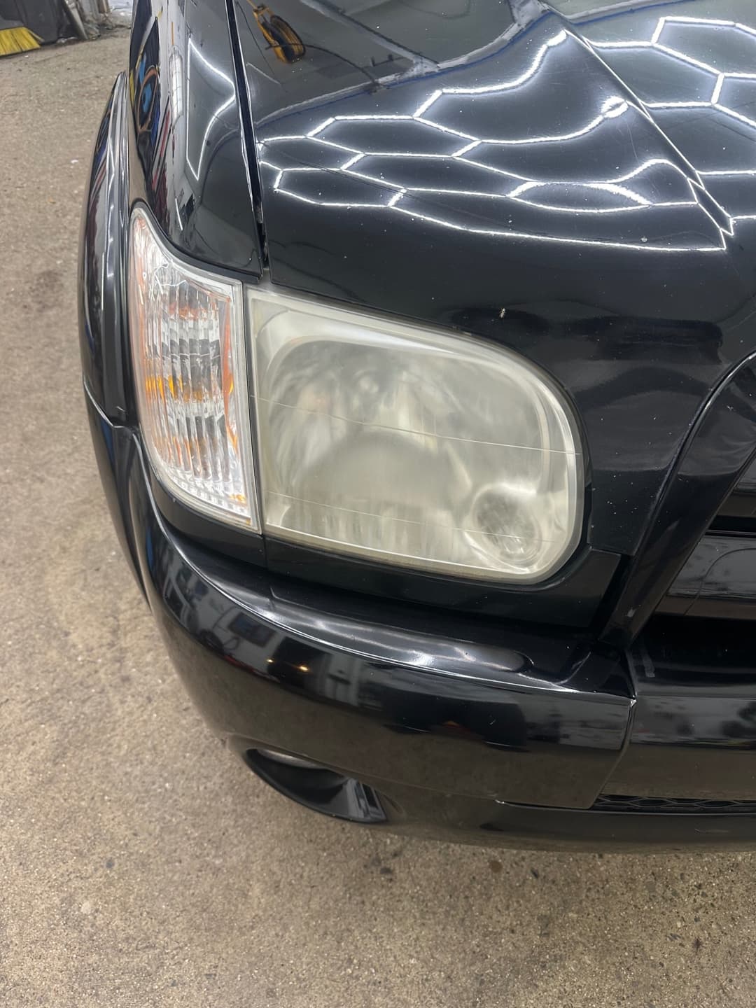 Headlight restoration before service showing cloudy and oxidized lens